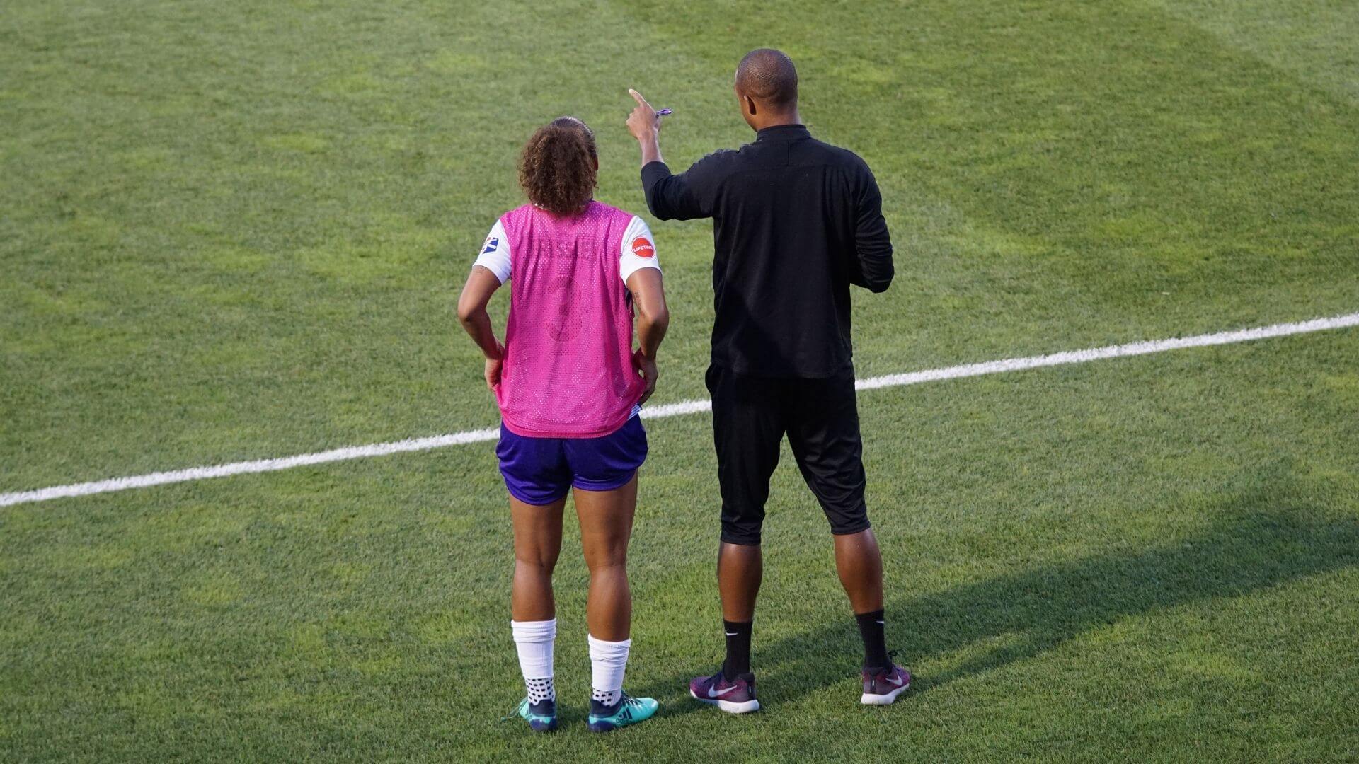 women's soccer player talking to coach